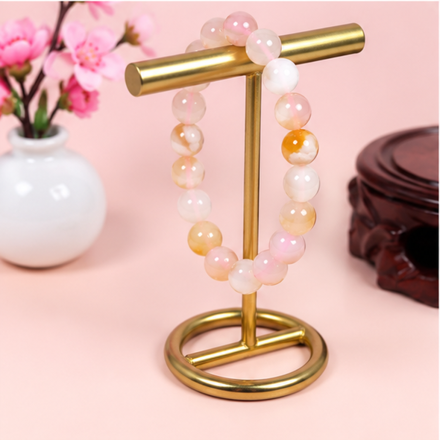 Bracelet extensible en agate fleur de cerisier présenté sur un support